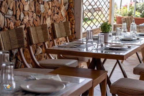 a group of tables and chairs with plates on them at Vournelis Beach Hotel and Spa in Iraklitsa