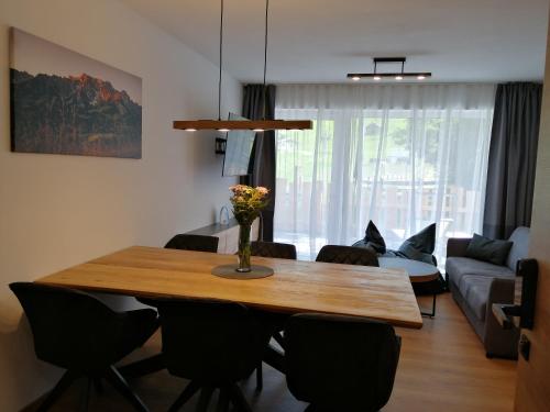 Das Prinzenberg Appartement في ماريا ألم آم شتاينرنين مير: غرفة معيشة مع طاولة وكراسي خشبية