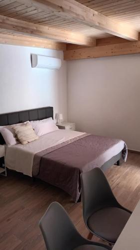 um quarto com uma cama grande e 2 cadeiras em B&B JoseyMaria em Marina di Camerota