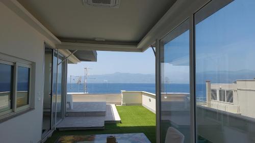 a house with a view of the ocean from a balcony at Attico Sottovento in Reggio Calabria