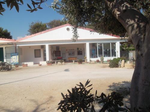 a building with a tree in front of it at Capo Scalambri in Santa Croce Camerina