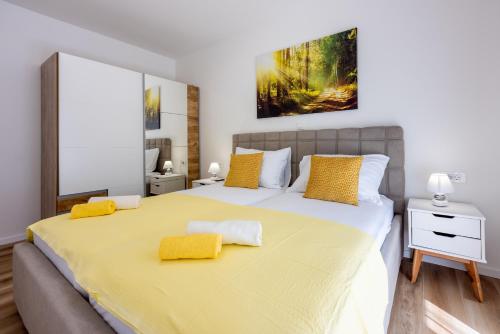 ein Schlafzimmer mit einem großen Bett mit gelben Kissen in der Unterkunft Villa Una in Krk