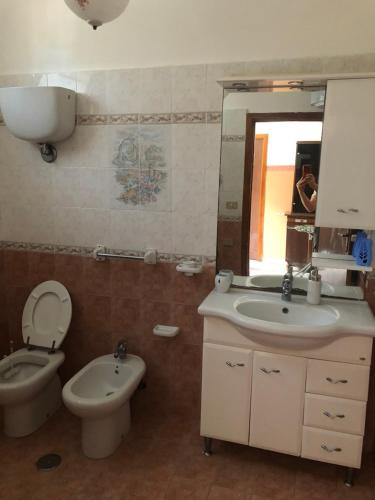 y baño con aseo, lavabo y espejo. en Casa bianca 2, en Tripatni
