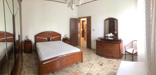 1 dormitorio con 2 camas de madera y espejo en Casa bianca 2, en Tripatni