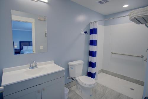 een badkamer met een wastafel, een toilet en een douche bij Dhimas Bayview Suites in Ocean City