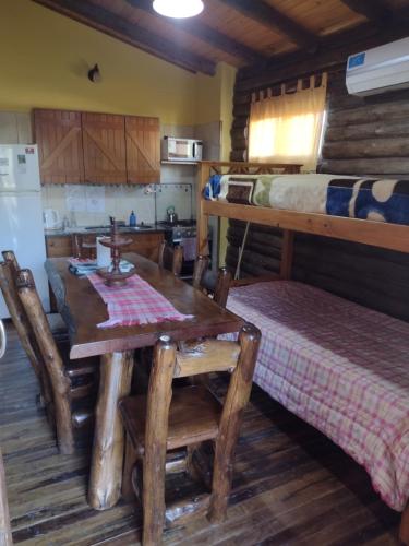 a dining room with a table and a bunk bed at Cabañas y Bungalow " La Comarca" in Concepción del Uruguay