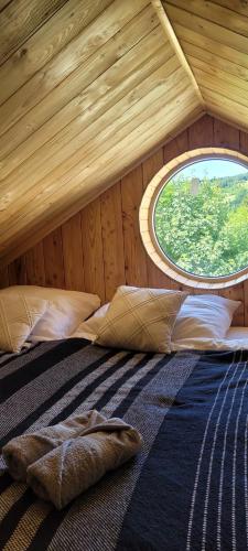a bedroom with a large bed with a round window at Domki na Widoku in Lubomierz