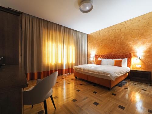 a bedroom with a bed and a table and a chair at Boutique Central in Sibiu
