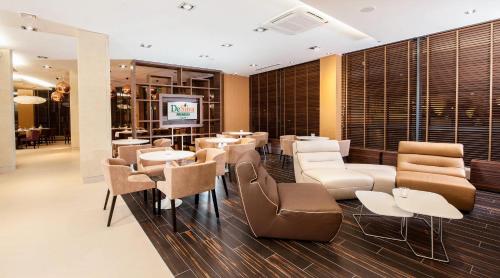 a restaurant with tables and chairs and a television at Hotel DeSilva Premium Opole in Opole