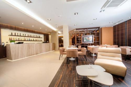 a restaurant with tables and chairs and a bar at Hotel DeSilva Premium Opole in Opole