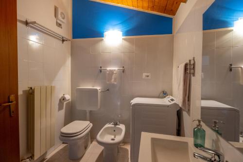 a bathroom with a white toilet and a sink at Happy Guest Apartments - Blue Lake Therapy in Riva di Solto