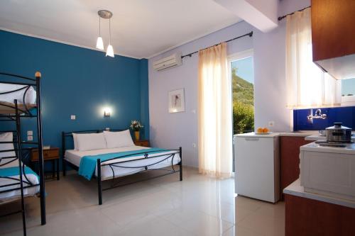 1 dormitorio con cama y pared azul en Jimmy's House, en Nikiana