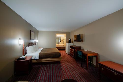 a hotel room with a bed and a desk at Brentwoodinn&suites in Glen Allen