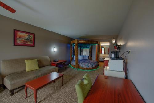 a living room with a couch and a bed at Brentwoodinn&suites in Glen Allen