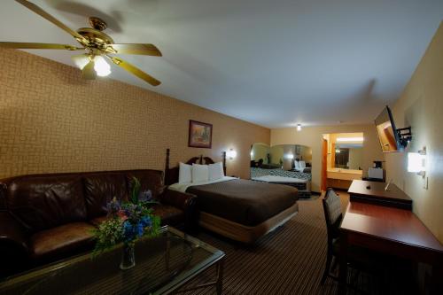 a living room with a couch and a bed in a room at Brentwoodinn&suites in Glen Allen