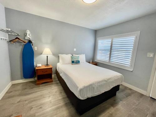 a bedroom with a large bed and a window at The Palomar Inn in Pismo Beach