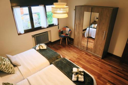 1 dormitorio con 1 cama y 1 habitación con espejo en La Casona de la Carbayeda, en Oviedo