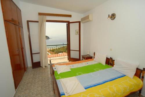 a bedroom with a bed with a view of the ocean at Villa Zaharo and Lilian Apartments in Troulos
