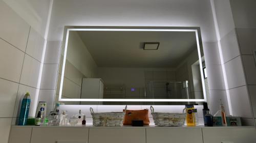 un bagno con un grande specchio sopra un lavandino di Elegantes & modernes Apartment NeLi mit Terrasse, 100m zum Hafen Röbel Müritz a Röbel