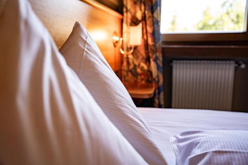 a white bed with white sheets and a window at PanoramaHotel Penegal in Mendola