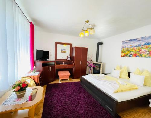 Schlafzimmer mit einem Bett, einem Tisch und einem Spiegel in der Unterkunft Apartmany pod Troma Korunami in Červený Kláštor