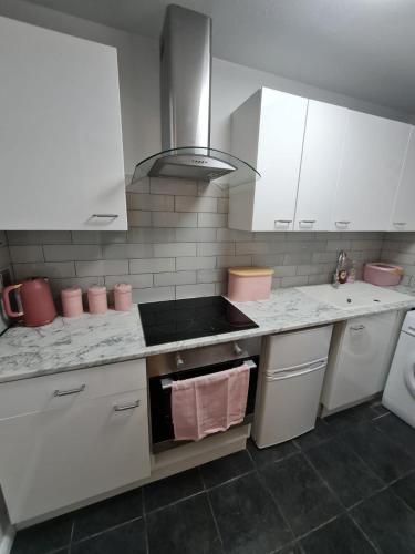 a kitchen with white cabinets and a stove top oven at Lovely 2 bedroom flat in nice Inversness area. in Inverness
