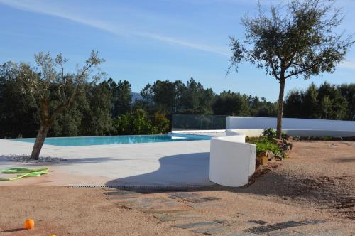 a villa with a swimming pool and a tree at Ouzenda do Zêzere in Pedrógão Grande