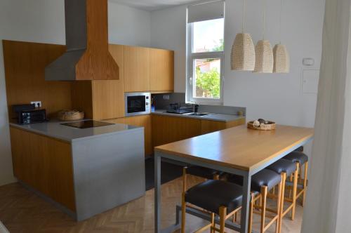a kitchen with a counter and a table with chairs at Ouzenda do Zêzere in Pedrógão Grande