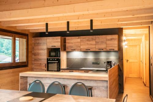 a kitchen with wooden walls and a table and chairs at CHALET LES CERFS in Châtel
