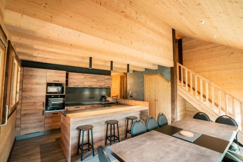 a kitchen with wooden walls and tables and chairs at CHALET LES CERFS in Châtel