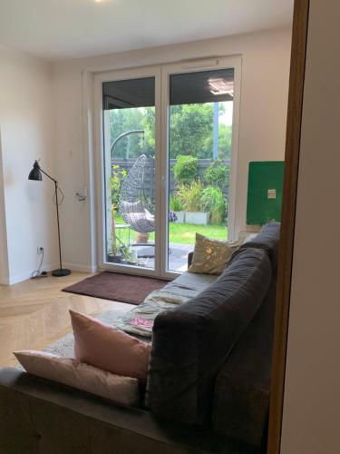 a couch in a living room with a sliding glass door at Garden Apartament - Self Check-In - wejdź już teraz in Krakow