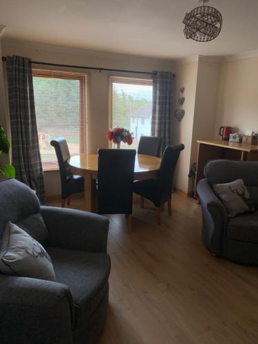 a living room with a table and chairs at No 52 - Apartment with Lounge and Dining Area - No kitchen in Ullapool