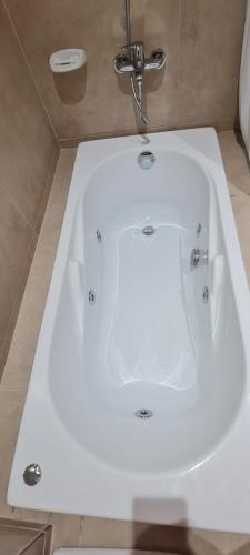 a white bath tub with a faucet in a bathroom at Puerto La Casa in San Martín de los Andes