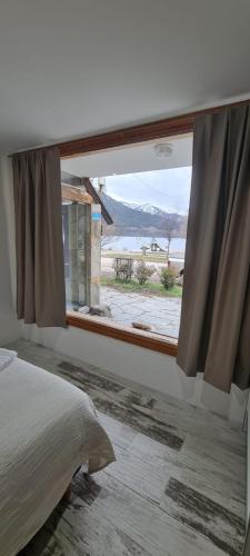 a bedroom with a window with a view of the ocean at Puerto La Casa in San Martín de los Andes