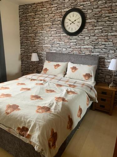 1 dormitorio con 1 cama con reloj en la pared en No 52 - Apartment with Lounge and Dining Area - No kitchen, en Ullapool
