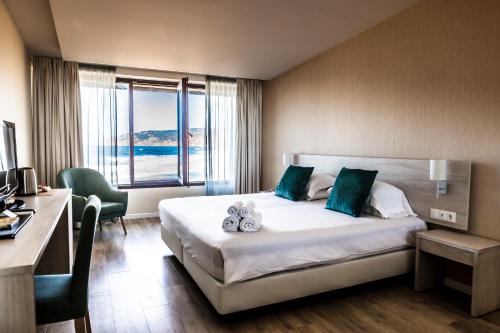 a hotel room with a bed and a large window at Estalagem Muchaxo Hotel in Cascais