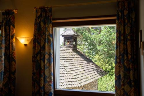 a window with a view of a tile roof at PanoramaHotel Penegal in Mendola