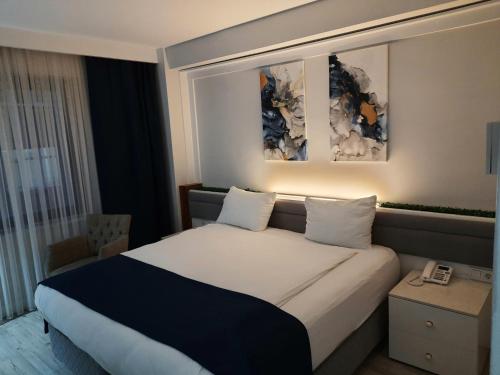 Un pat sau paturi într-o cameră la Nadir Business Hotel