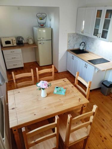 a kitchen with a wooden table with chairs and a refrigerator at Chalupa pod Volarským rondelem in Volary