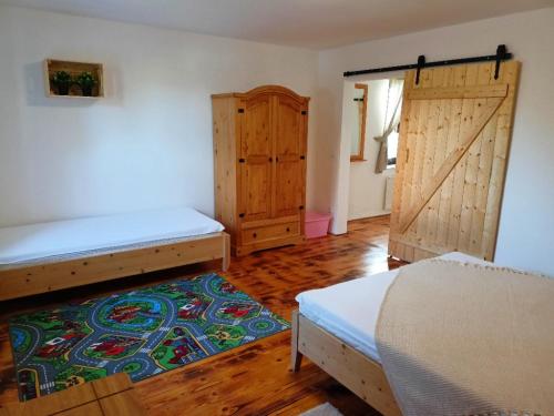 a bedroom with two beds and a sliding door at Chalupa pod Volarským rondelem in Volary