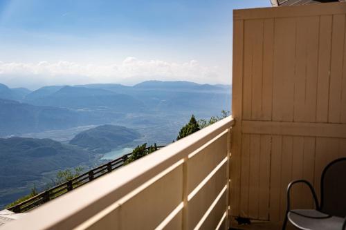a balcony of a house with a view of the mountains at PanoramaHotel Penegal in Mendola