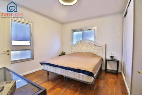 1 dormitorio con 1 cama y 2 ventanas en Sea view family relax apartment, en Netanya