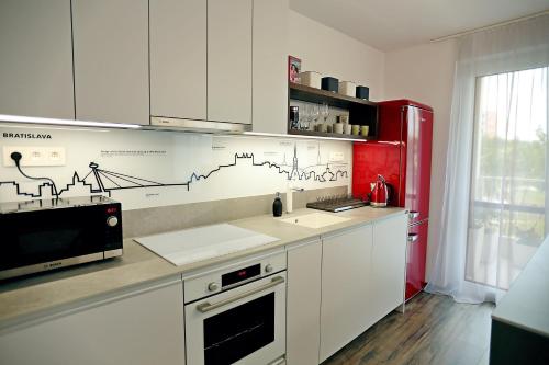 a kitchen with a counter with a microwave and a refrigerator at Modern apartment near the city centre URBAN in Bratislava