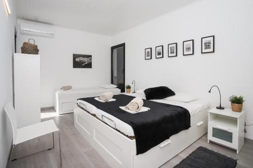 biała sypialnia z dużym łóżkiem z czarną pościelą w obiekcie Villa Broda w mieście Brodarica