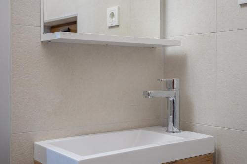 a white sink in a bathroom with a shelf at Monte Pino Lux Apartments in Žabljak