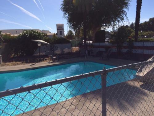 a swimming pool with a fence around it at Vino Inn & Suites in Atascadero