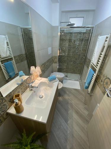 a bathroom with a sink and a toilet and a mirror at Civuleva! Casa vacanza Capo d Orlando in Capo dʼOrlando
