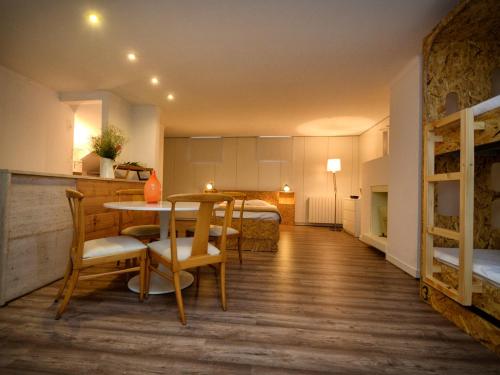 a room with a table and chairs and a bed at GuimaraesLiving - Hostel & Adventure in Guimarães