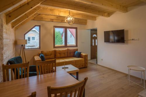 a living room with a couch and a table at Monte Pino Lux Apartments in Žabljak