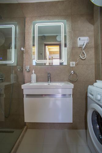 a bathroom with a sink and a washing machine at Monte Pino Lux Apartments in Žabljak